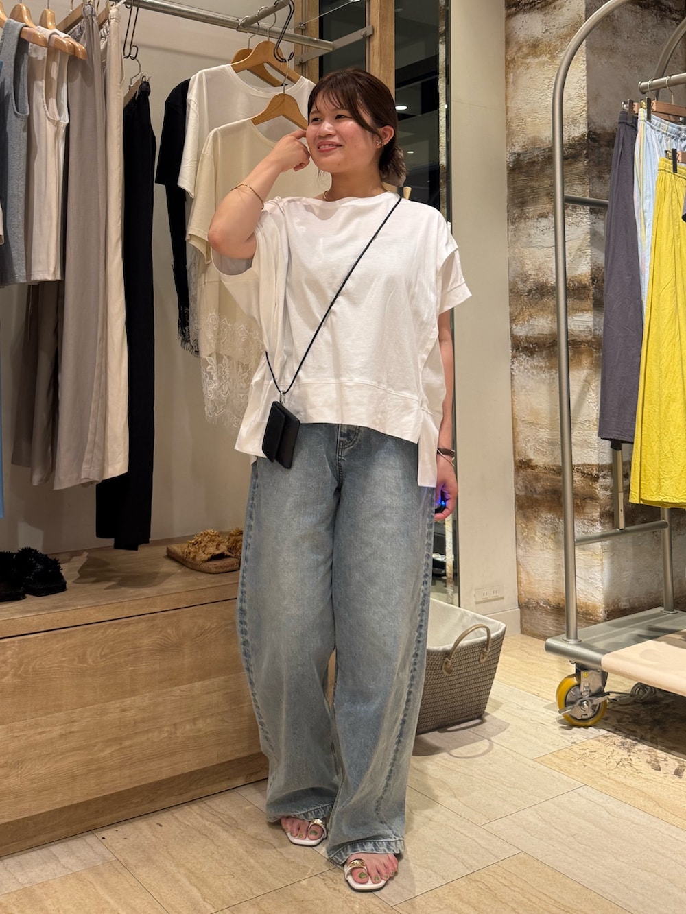 ホワイト系のTシャツ/カットソー、ブルー系のデニムパンツを着用したレディースの夏コーディネートの2枚目の写真