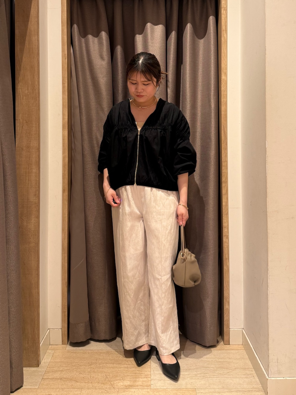 ベージュ系のその他パンツ、ブラック系のブルゾンを着用したレディースの春コーディネートの4枚目の写真