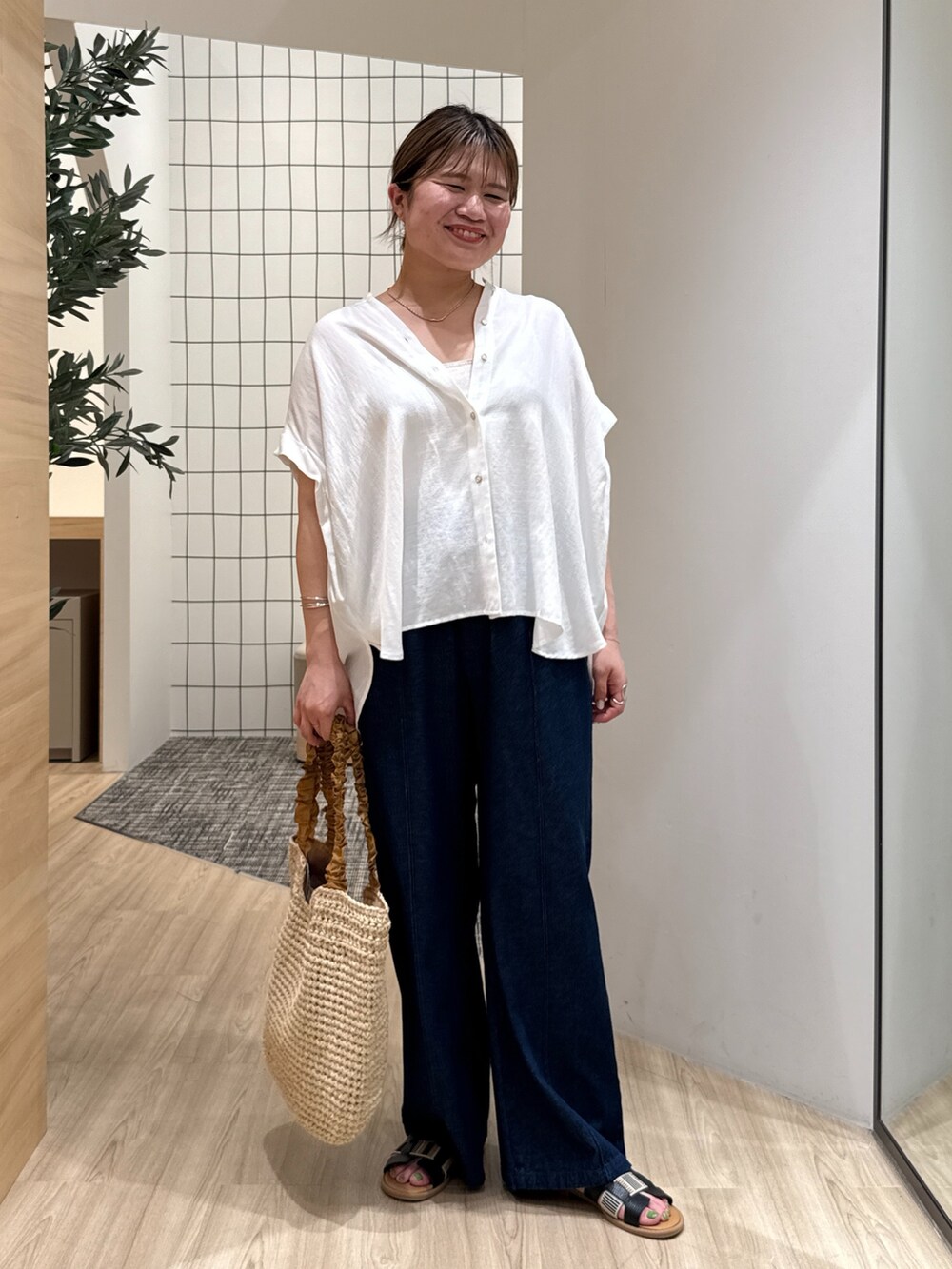 ホワイト系のシャツ/ブラウス、ブルー系のデニムパンツ、ベージュ系のトートバッグを着用したレディースの夏コーディネートの2枚目の写真