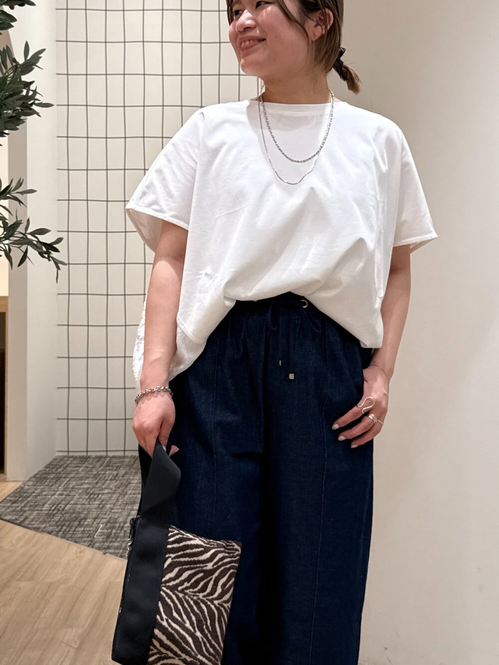 ブルー系のデニムパンツ、ホワイト系のTシャツ/カットソー、ホワイト系のサンダルを着用したレディースの夏コーディネートの5枚目の写真