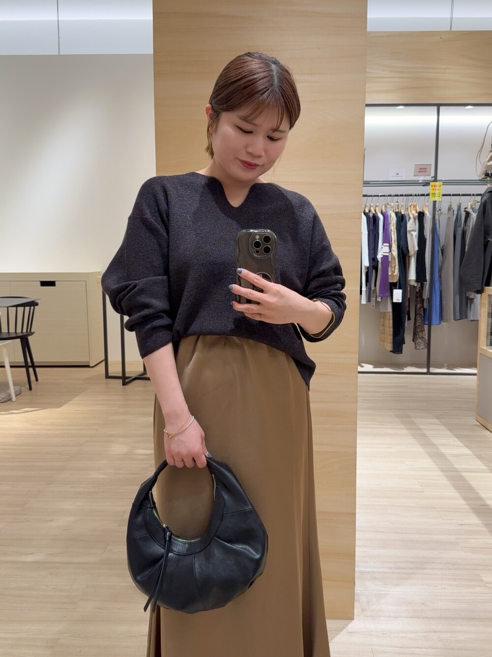 イエロー系のスカート、グレー系のニット/セーター、ブラック系のパンプスを着用したレディースの秋コーディネートの4枚目の写真