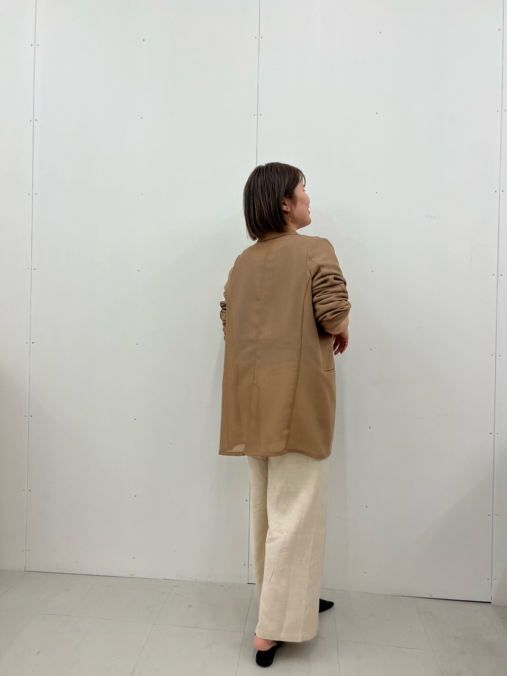 ベージュ系のテーラードジャケット、ブルー系のニット/セーター、ベージュ系のその他パンツを着用したレディースの春コーディネートの3枚目の写真