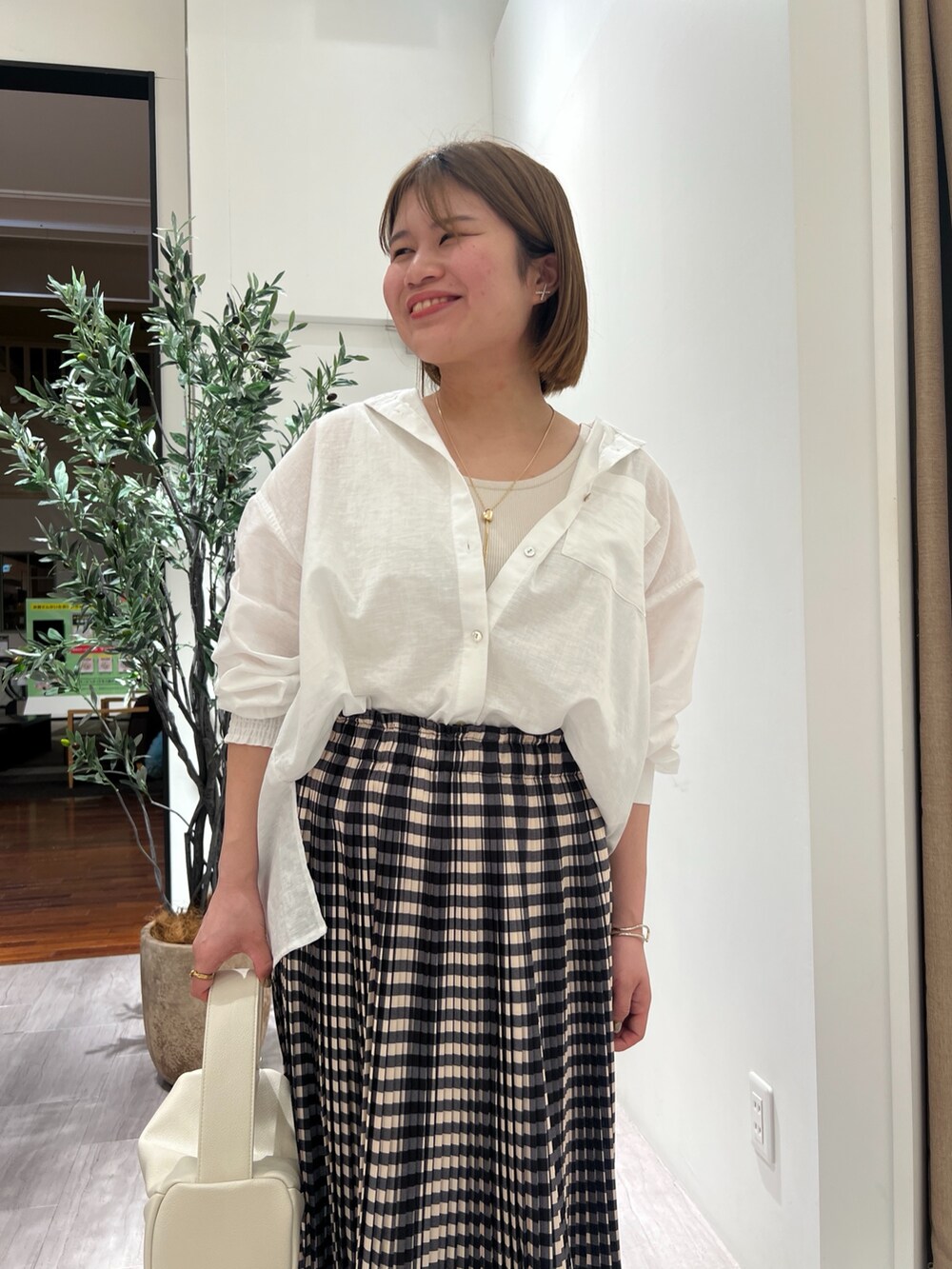 ホワイト系のシャツ/ブラウス、ベージュ系のキャミソール、ホワイト系のトートバッグを着用したレディースの春コーディネートの4枚目の写真