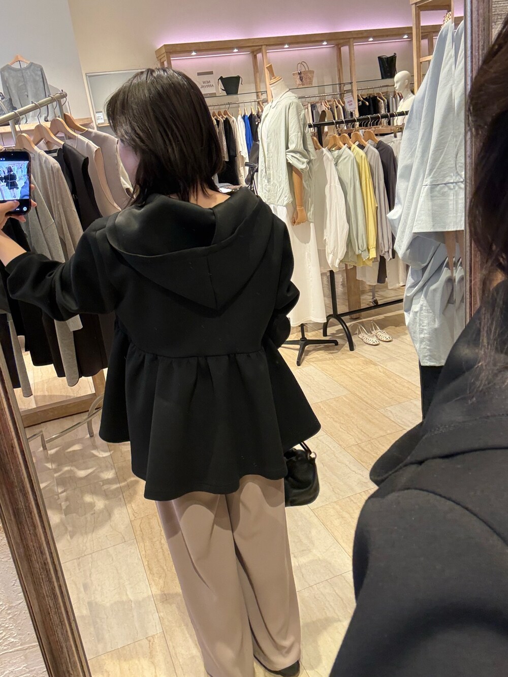 ブラック系のパーカー、ベージュ系のその他パンツ、ブラック系のトートバッグを着用したレディースの春コーディネートの3枚目の写真