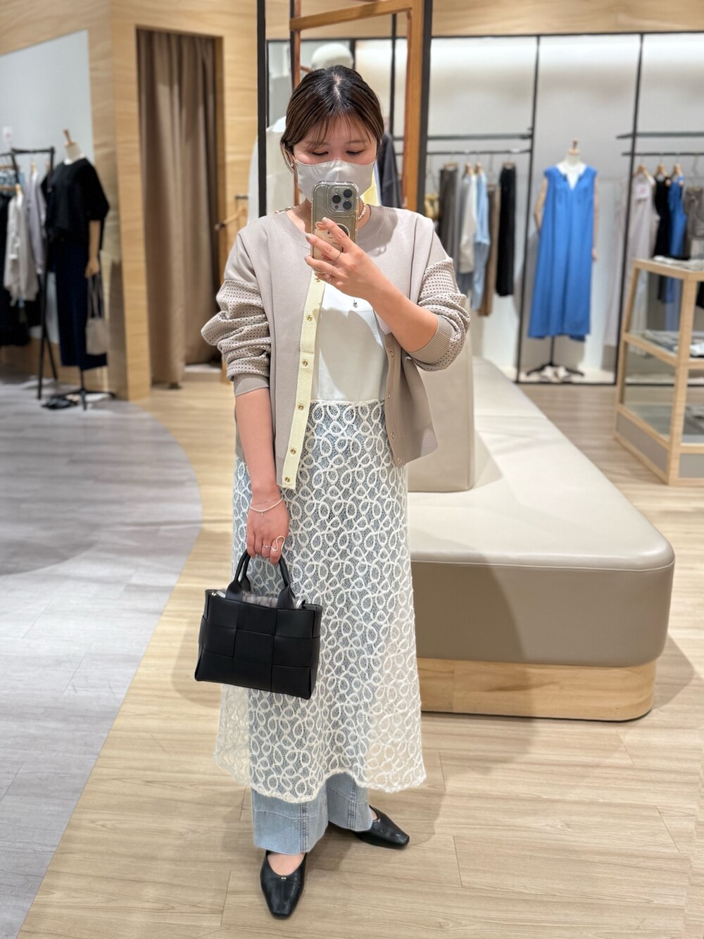 ホワイト系のワンピース、グレー系のカーディガン/ボレロ、ブラック系のトートバッグを着用したレディースの夏コーディネートの2枚目の写真