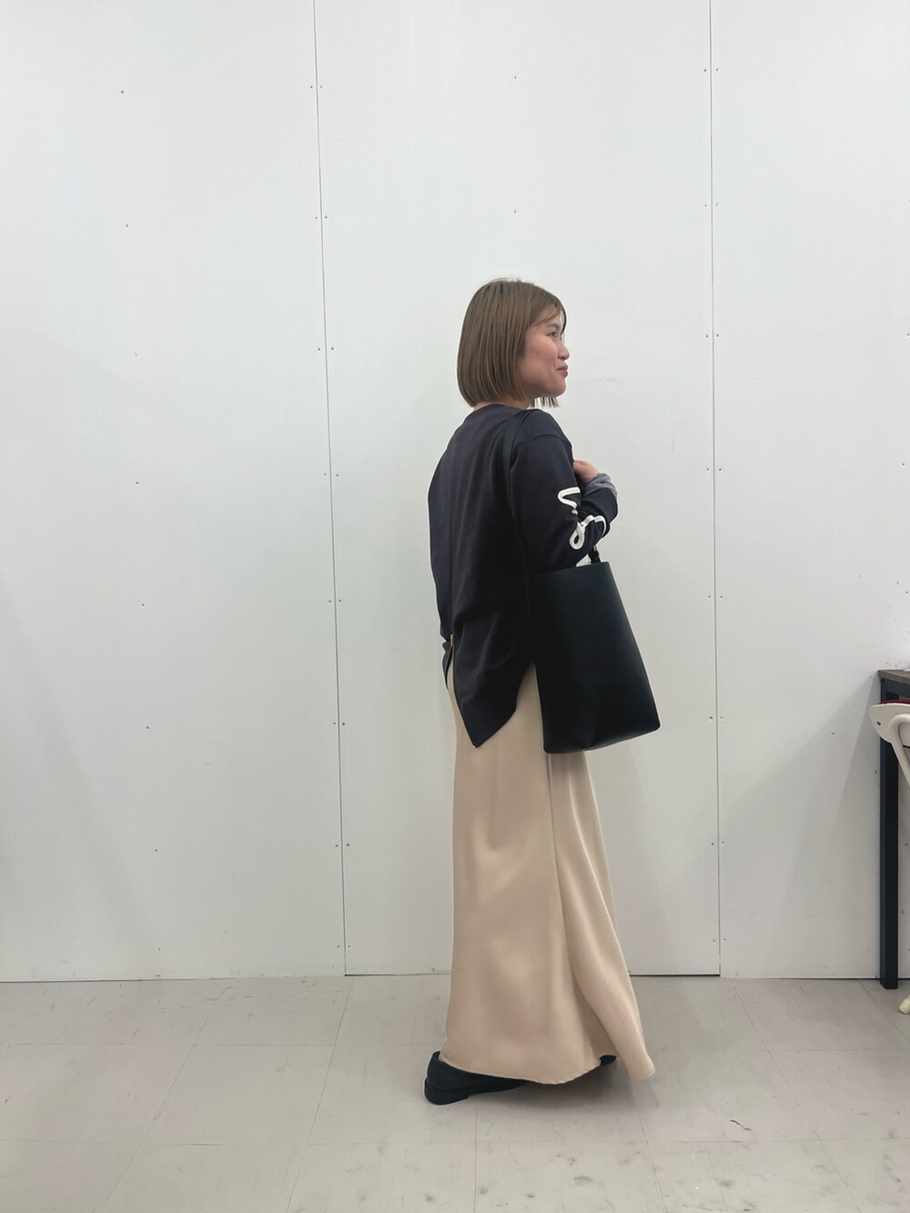 ベージュ系のスカート、グレー系のTシャツ/カットソーを着用したレディースの冬コーディネートの2枚目の写真