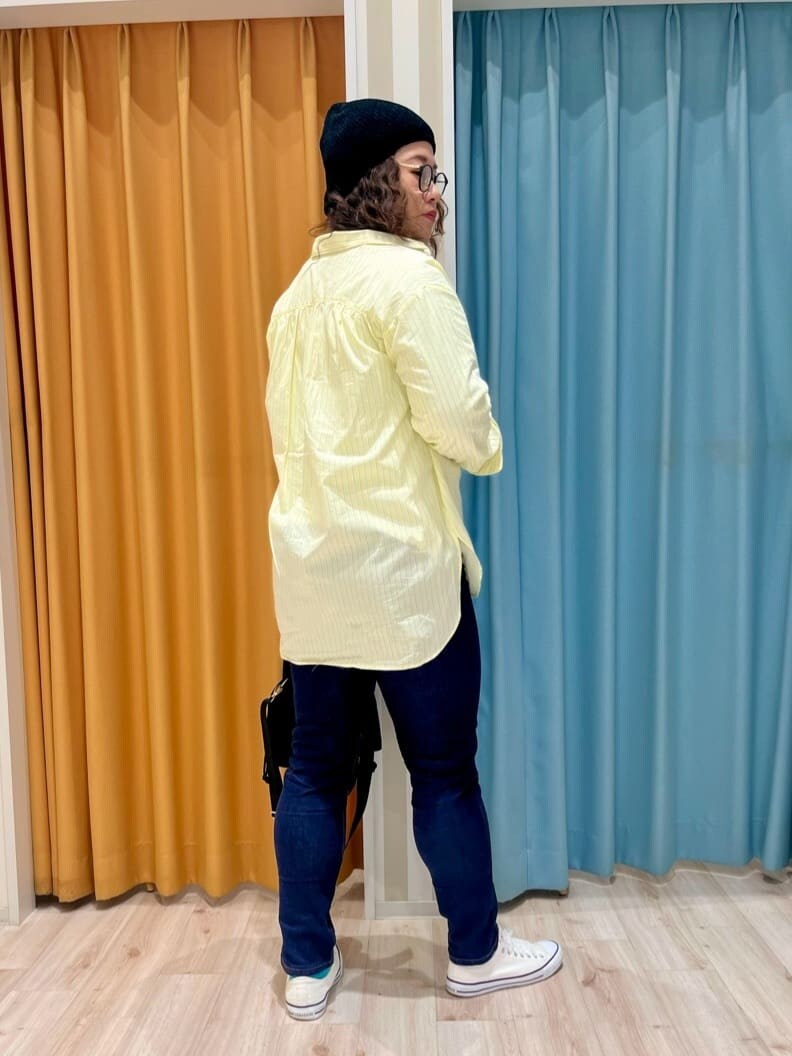 ブルー系のデニムパンツ、ホワイト系のTシャツ/カットソー、イエロー系のシャツ/ブラウスを着用したレディースの春コーディネートの3枚目の写真
