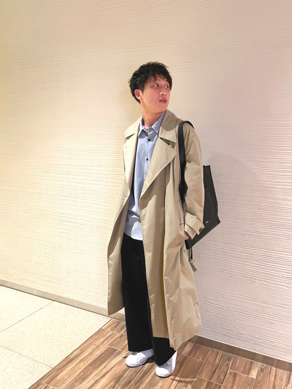ブラック系のトートバッグ、ベージュ系のトレンチコート、ブルー系のシャツ/ブラウスを着用したメンズの秋コーディネートの2枚目の写真