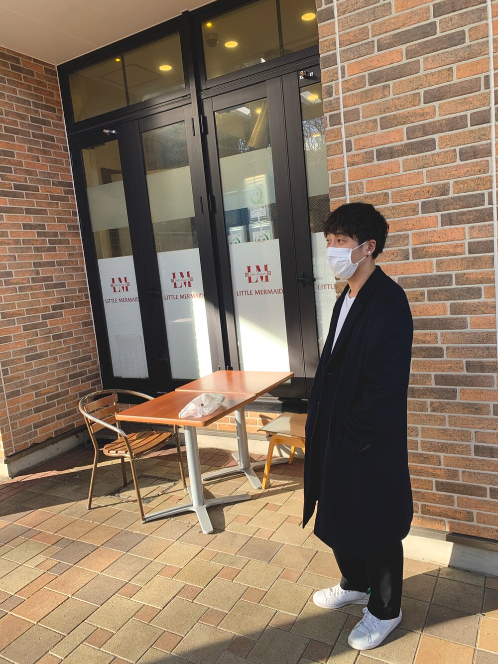 ホワイト系のニット/セーター、ブラック系のスラックス、ホワイト系のスニーカーを着用したメンズの冬コーディネートの2枚目の写真