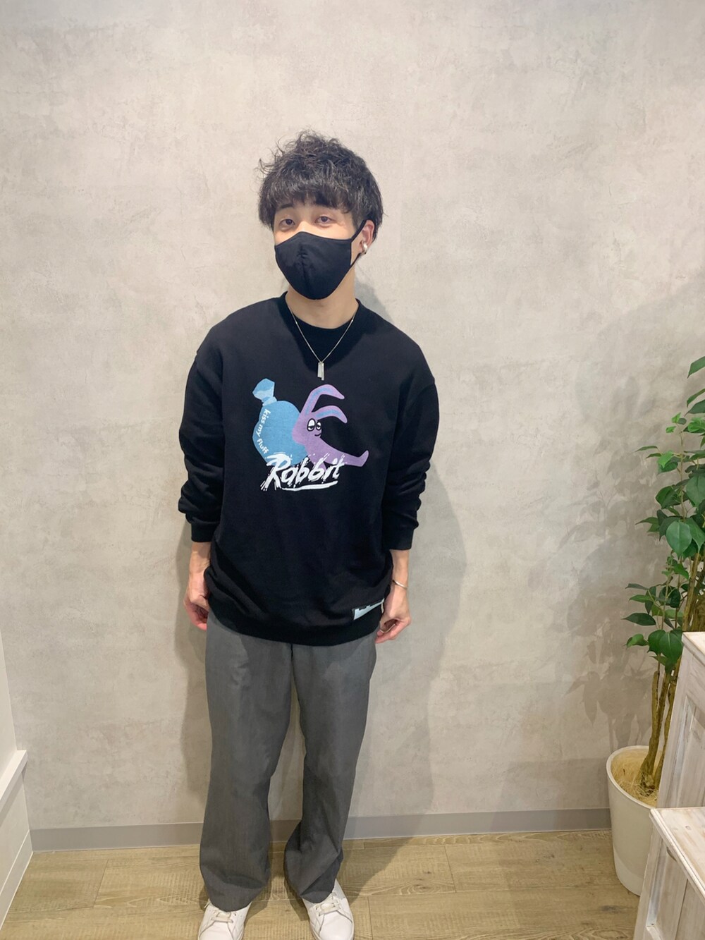 ブラック系のスウェット、グレー系のスラックス、ホワイト系のスニーカーを着用したメンズの春コーディネートの2枚目の写真