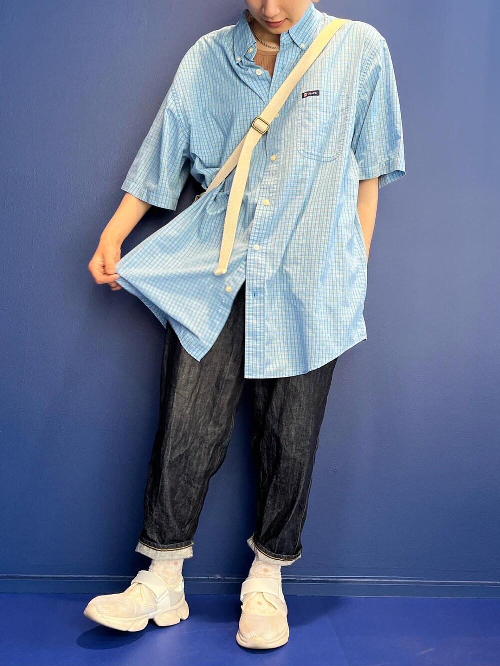 ブルー系のシャツ/ブラウス、ブルー系のデニムパンツ、ホワイト系のスニーカーを着用したレディースの夏コーディネートの2枚目の写真