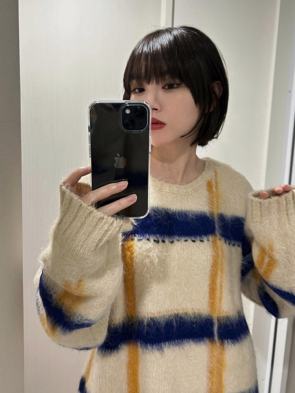 ホワイト系のニット/セーターを着用したレディースの冬コーディネートの2枚目の写真