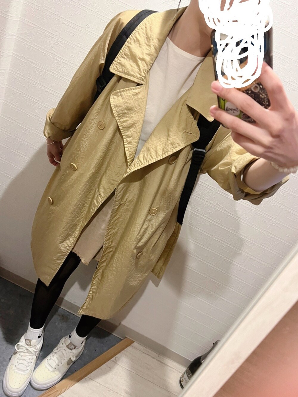 ホワイト系のスニーカー、ベージュ系のデニムスカート、ベージュ系のトレンチコートを着用したレディースの春コーディネートの2枚目の写真