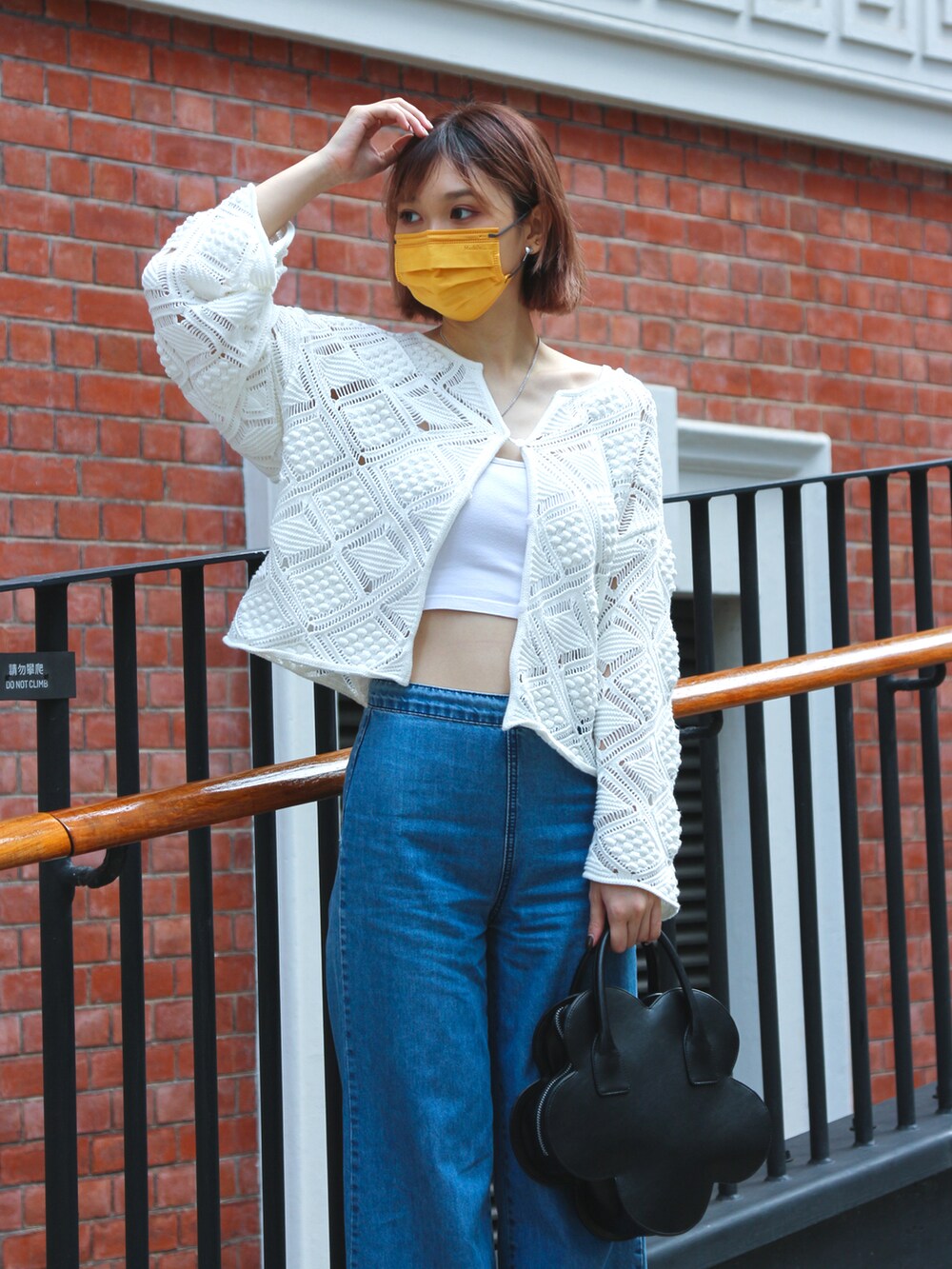 ホワイト系のサンダル、ホワイト系のカーディガン/ボレロ、ブラック系のトートバッグを着用したレディースの春コーディネートの2枚目の写真