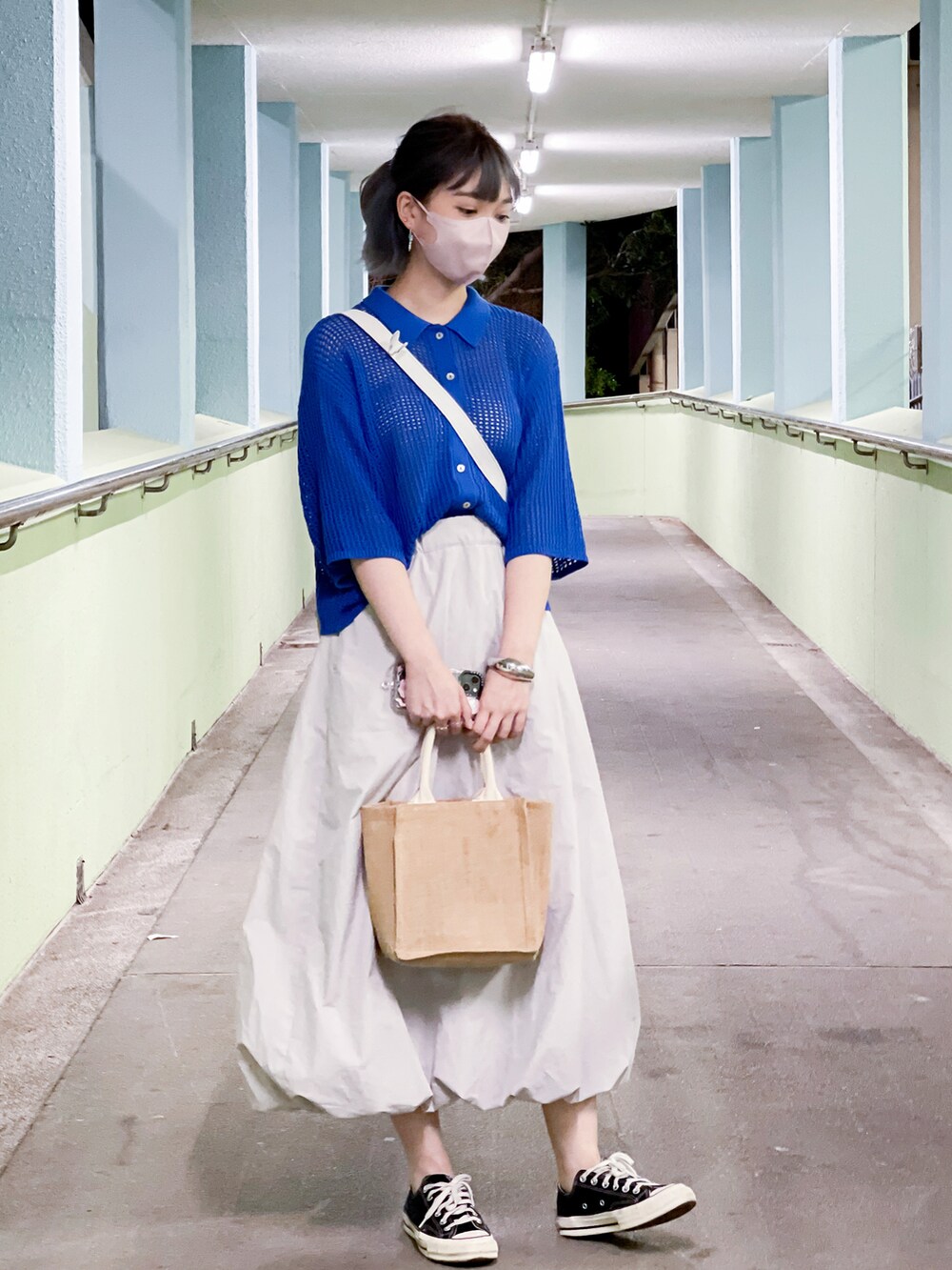 ブラウン系のバッグ、ブルー系のカーディガン/ボレロ、グレー系のスカートを着用したレディースの夏コーディネートの2枚目の写真
