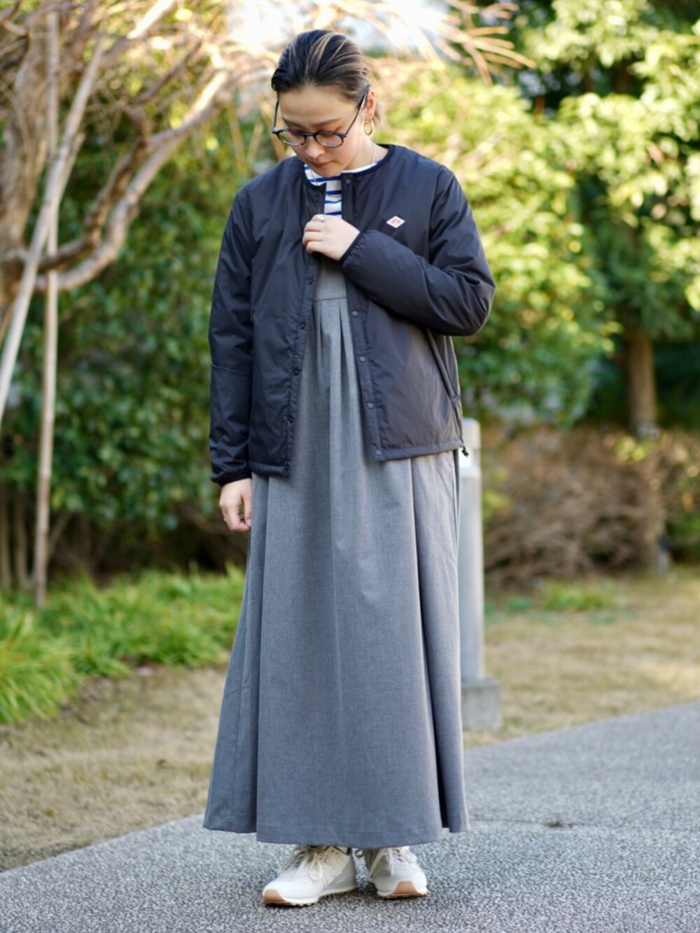 ブラック系のブルゾン、グレー系のジャンパースカート、ブルー系のTシャツ/カットソーを着用したレディースの冬コーディネートの2枚目の写真