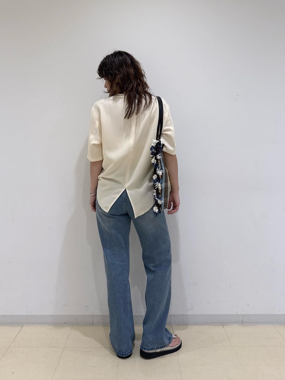 イエロー系のシャツ/ブラウス、ブルー系のデニムパンツ、イエロー系のトートバッグを着用したレディースの春コーディネートの4枚目の写真