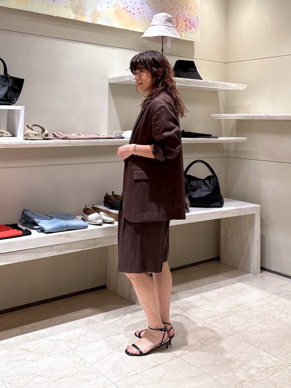 ブラウン系のその他パンツ、ブラック系のトートバッグ、ホワイト系のTシャツ/カットソーを着用したレディースの春コーディネートの3枚目の写真