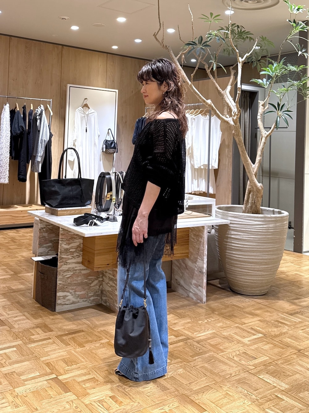 ブラック系のパーカー、ブラック系のシャツ/ブラウス、ブルー系のデニムパンツを着用したレディースの春コーディネートの2枚目の写真