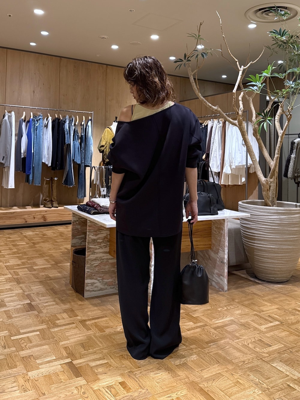 ブラック系のトートバッグ、ブルー系のスウェット、ブラック系のその他パンツを着用したレディースの秋コーディネートの3枚目の写真