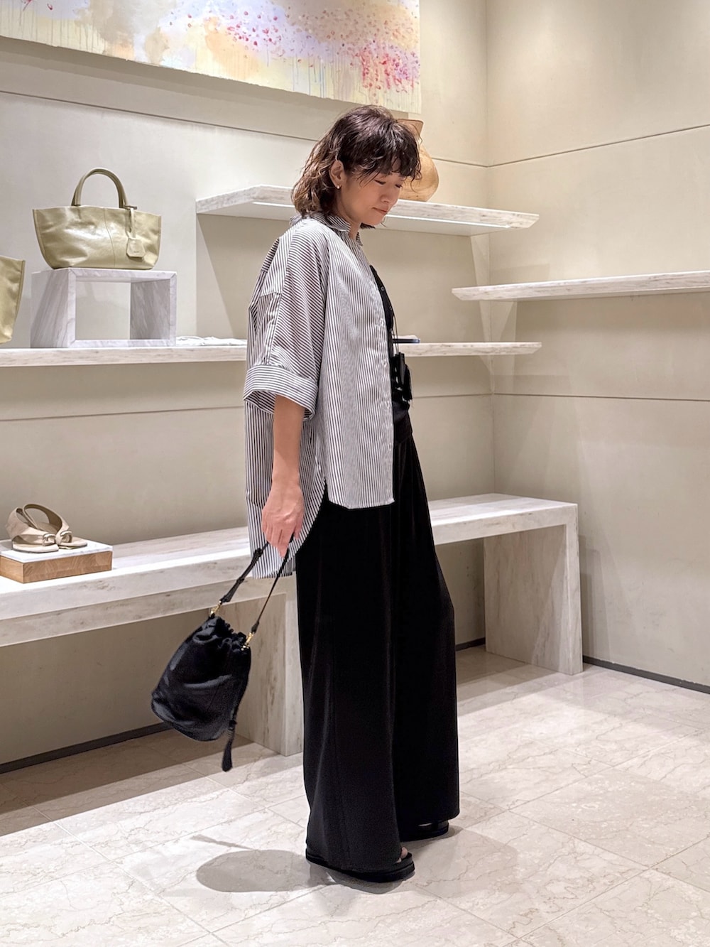 ブルー系のシャツ/ブラウス、ブラック系のその他パンツ、ブラック系のトートバッグを着用したレディースの夏コーディネートの2枚目の写真