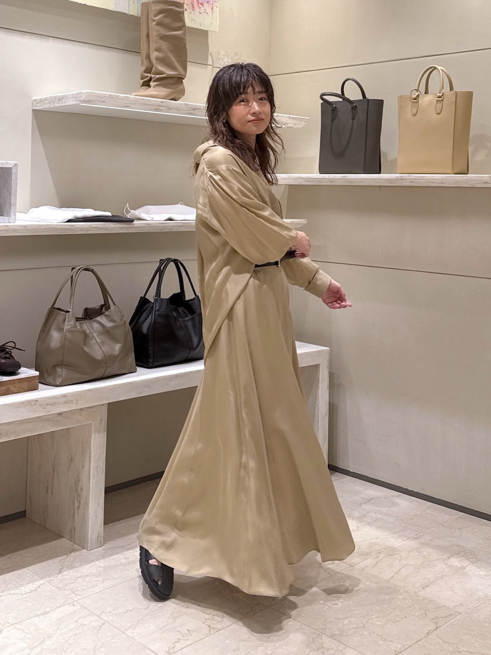 ベージュ系のスカート、ベージュ系のシャツ/ブラウス、ブラック系のサンダルを着用したレディースの春コーディネートの3枚目の写真