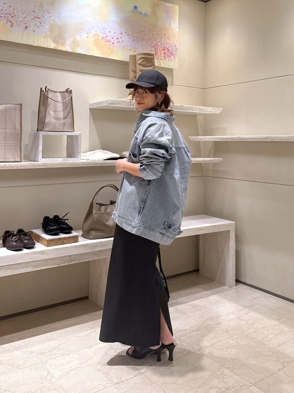 ブラック系のワンピース、ブルー系のベスト、ブラック系のサンダルを着用したレディースの冬コーディネートの2枚目の写真