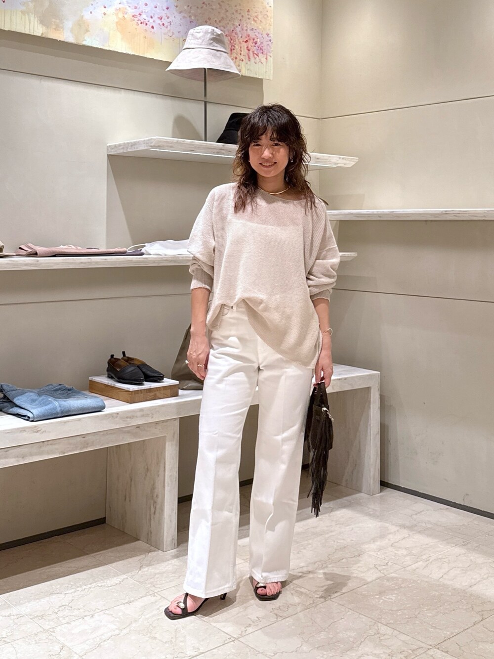 ブラウン系のサンダル、ホワイト系のデニムパンツ、ベージュ系のニット/セーターを着用したレディースの春コーディネートの3枚目の写真