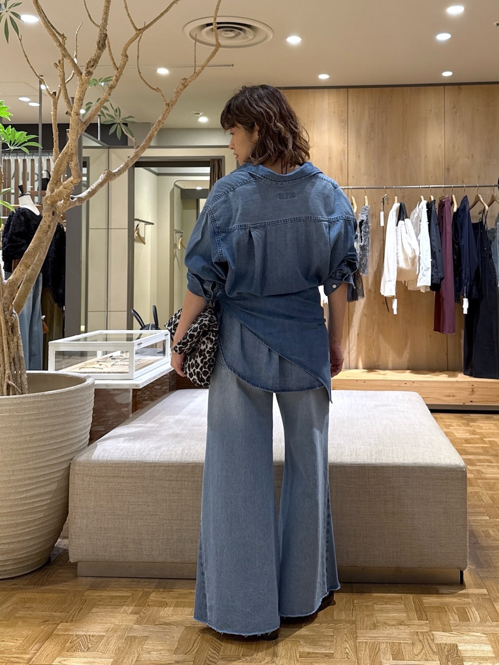 ブルー系のシャツ/ブラウス、ブルー系のデニムパンツ、ブラック系のトートバッグを着用したレディースの秋コーディネートの5枚目の写真
