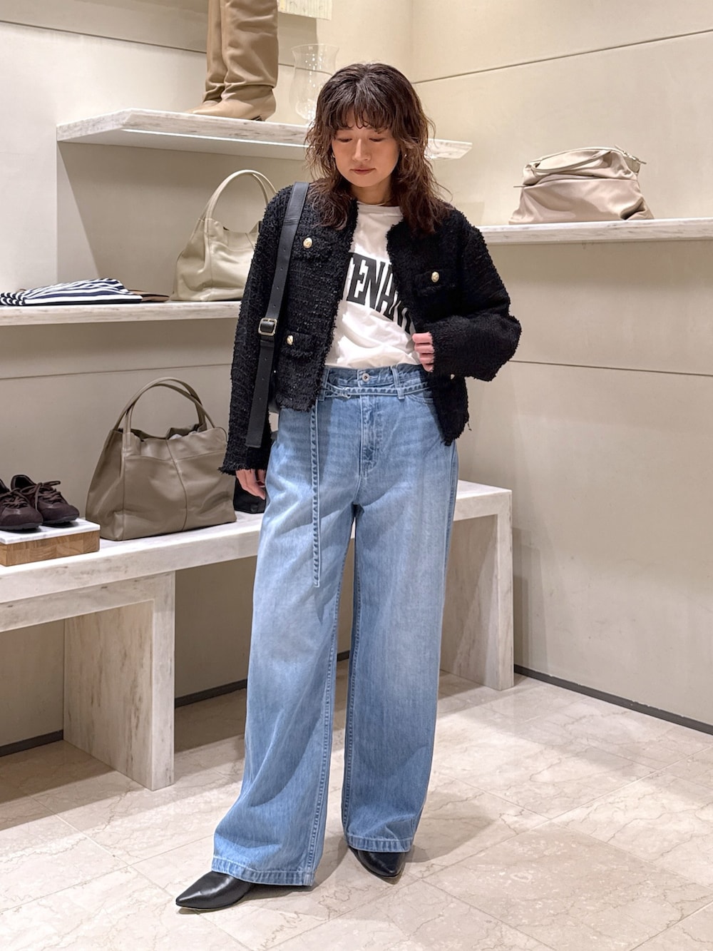 ブラック系のベスト、ホワイト系のTシャツ/カットソー、ブルー系のデニムパンツを着用したレディースの冬コーディネートの4枚目の写真