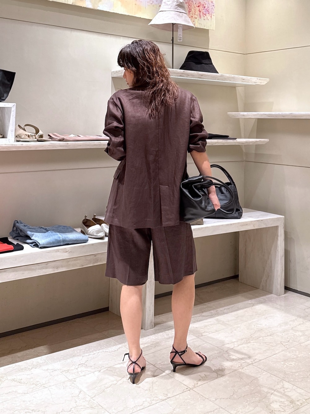 ブラウン系のその他パンツ、ブラック系のトートバッグ、ホワイト系のTシャツ/カットソーを着用したレディースの春コーディネートの4枚目の写真