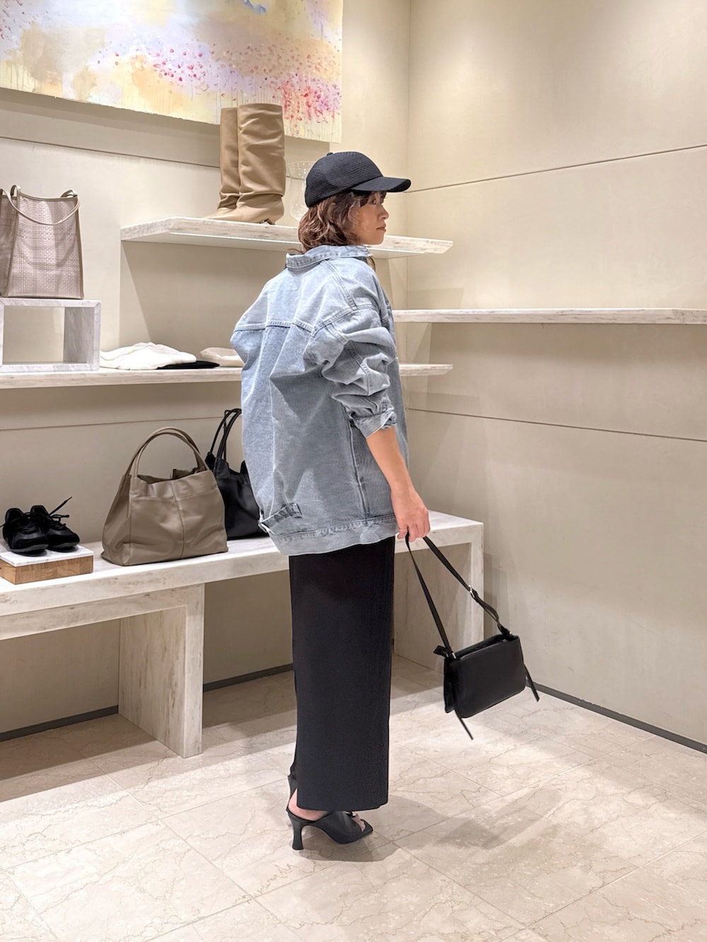 ブラック系のワンピース、ブルー系のベスト、ブラック系のサンダルを着用したレディースの冬コーディネートの3枚目の写真