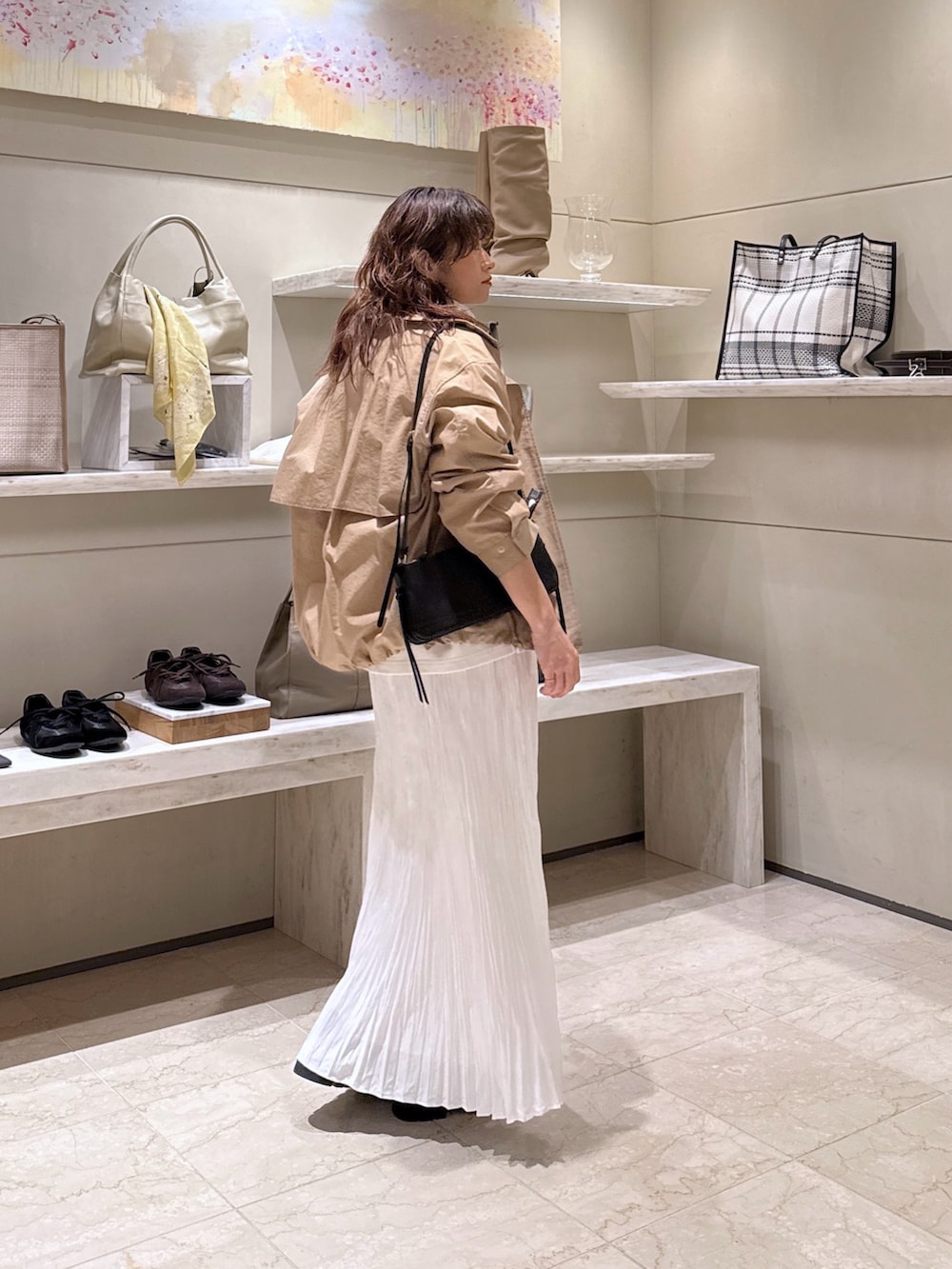 ベージュ系のブルゾン、ホワイト系のTシャツ/カットソー、ホワイト系のスカートを着用したレディースの冬コーディネートの2枚目の写真