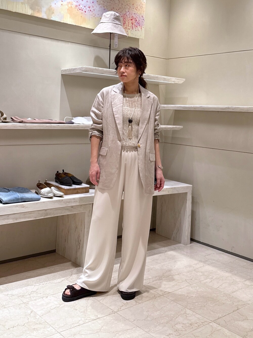 ベージュ系のその他パンツ、ブラウン系のサンダル、ホワイト系のその他アウターを着用したレディースの春コーディネートの4枚目の写真