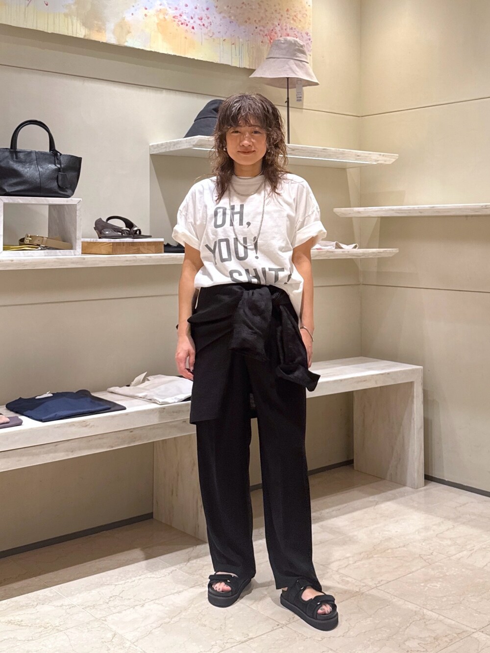 ブラック系のその他パンツ、ホワイト系のTシャツ/カットソー、ブラック系のサンダルを着用したレディースの春コーディネートの3枚目の写真