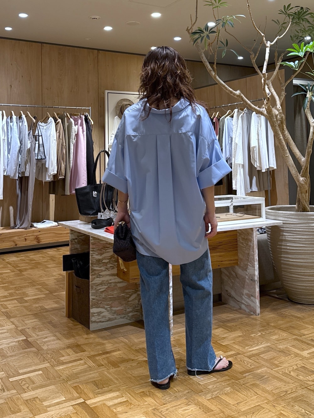 ブルー系のシャツ/ブラウス、ブルー系のデニムパンツ、ブラック系のショルダーバッグを着用したレディースの春コーディネートの3枚目の写真