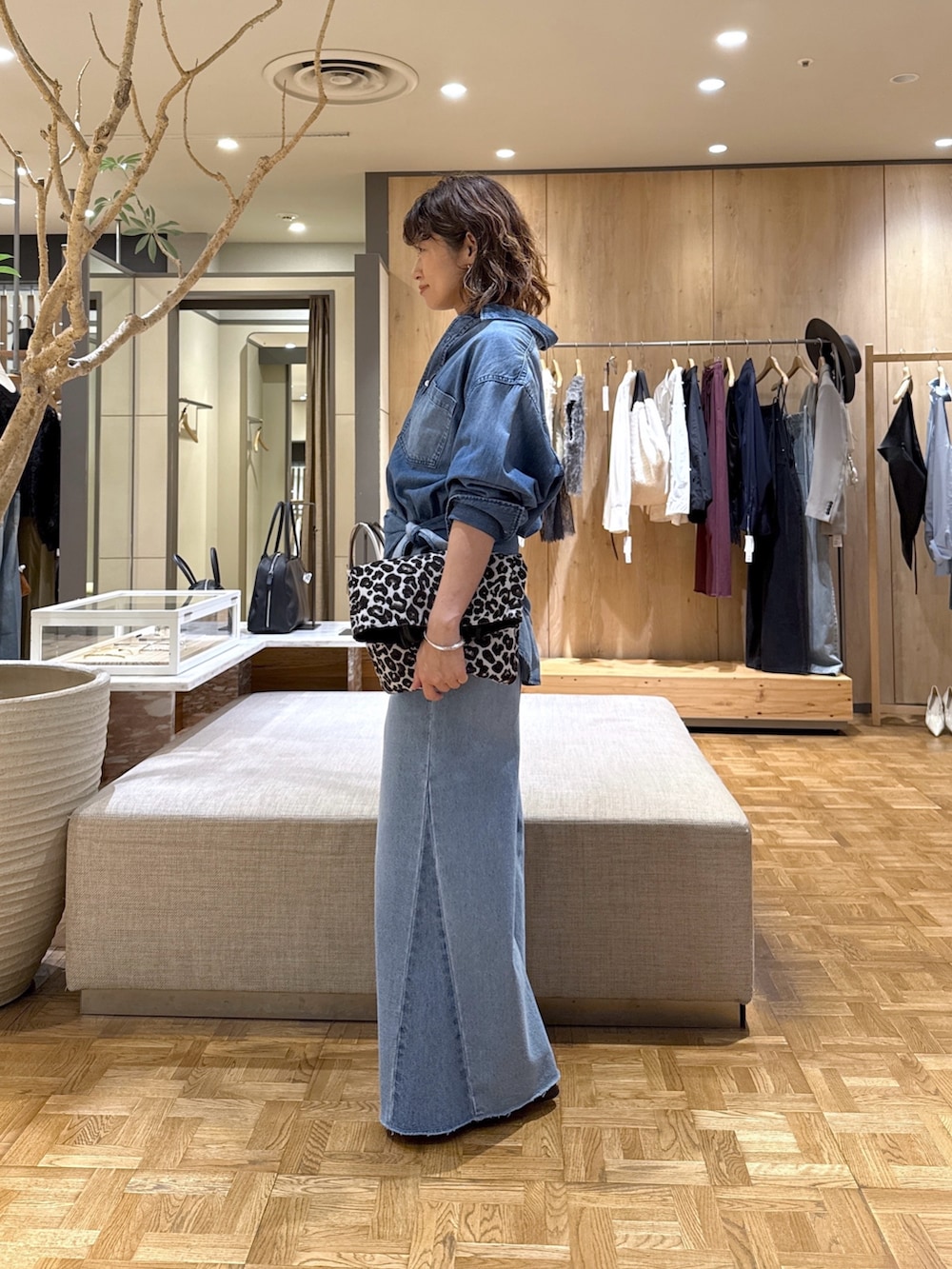ブルー系のシャツ/ブラウス、ブルー系のデニムパンツ、ブラック系のトートバッグを着用したレディースの秋コーディネートの4枚目の写真