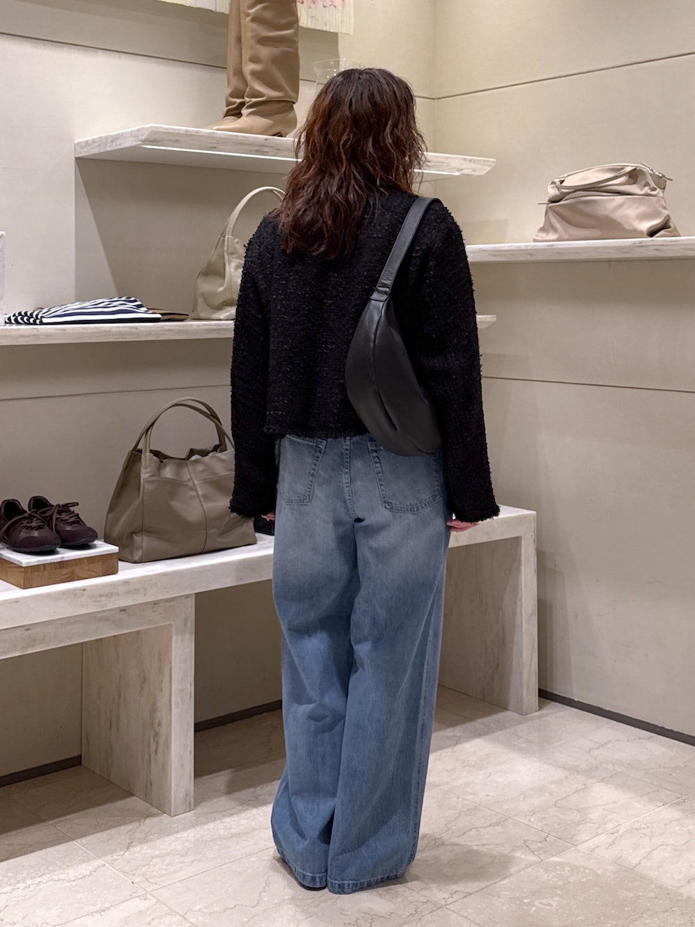 ブラック系のベスト、ホワイト系のTシャツ/カットソー、ブルー系のデニムパンツを着用したレディースの冬コーディネートの3枚目の写真