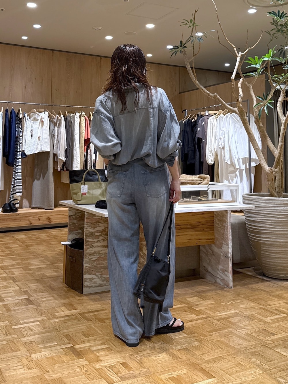 ブルー系のシャツ/ブラウス、ブルー系のその他パンツ、ブラック系のトートバッグを着用したレディースの夏コーディネートの3枚目の写真