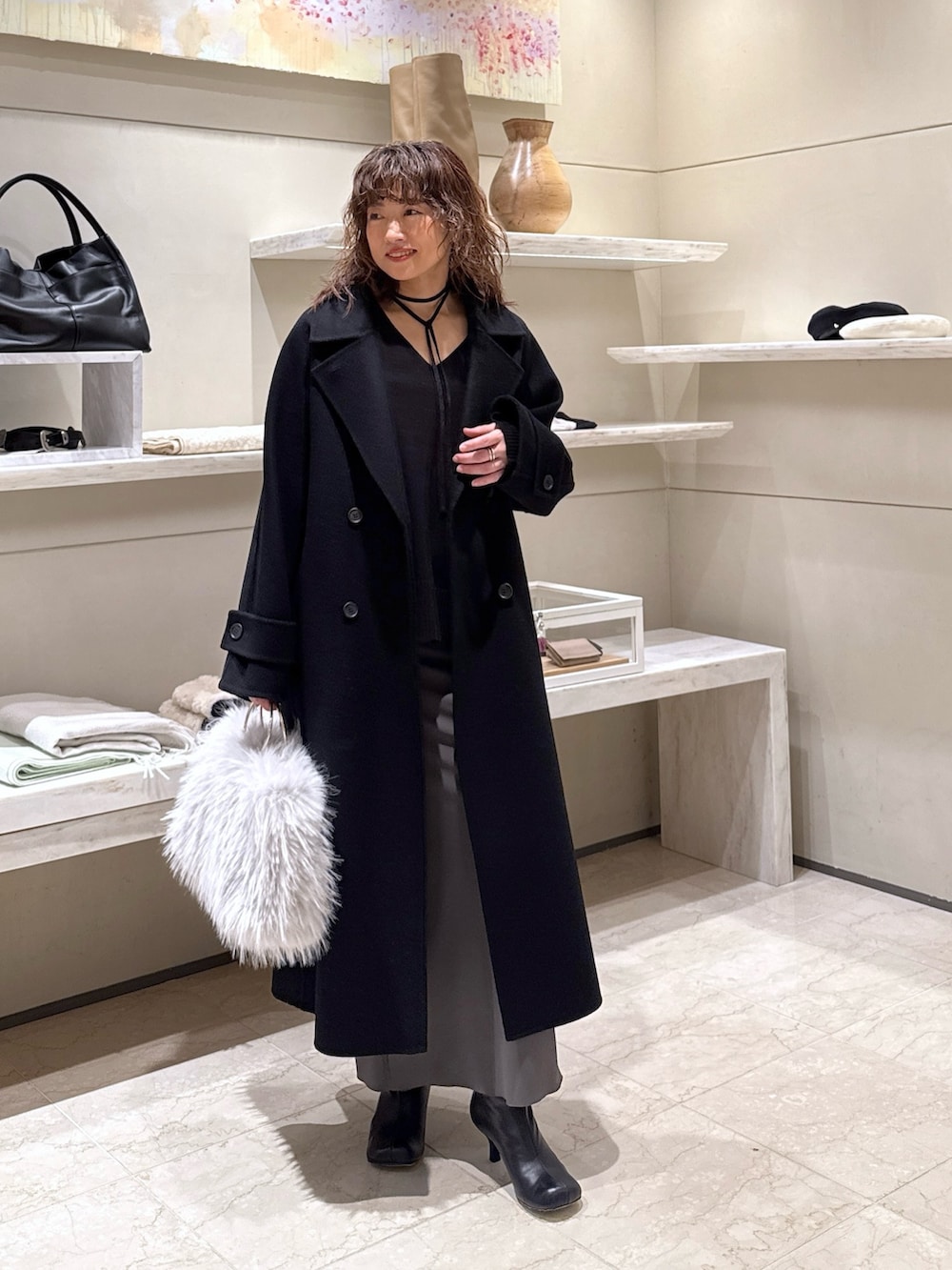 ブラック系のニット/セーター、グレー系のスカート、ブラック系のブーツを着用したレディースの冬コーディネートの5枚目の写真