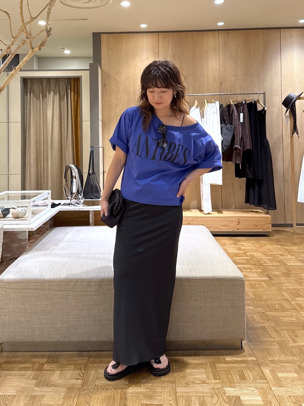 ブラック系のスカート、ブラック系のショルダーバッグ、ブルー系のTシャツ/カットソーを着用したレディースの春コーディネートの4枚目の写真