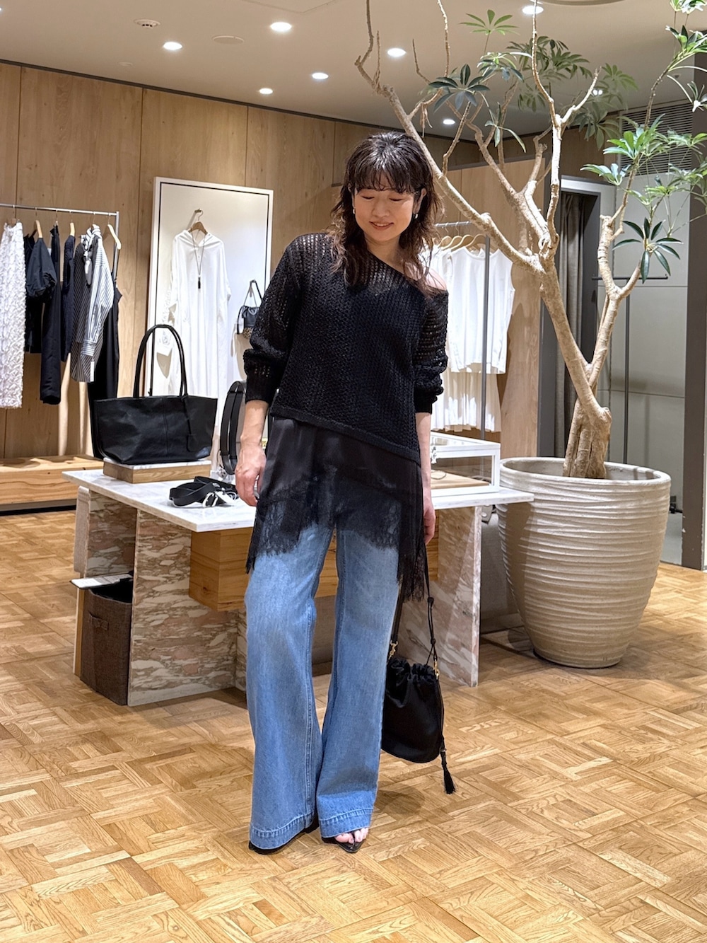 ブラック系のパーカー、ブラック系のシャツ/ブラウス、ブルー系のデニムパンツを着用したレディースの春コーディネートの4枚目の写真