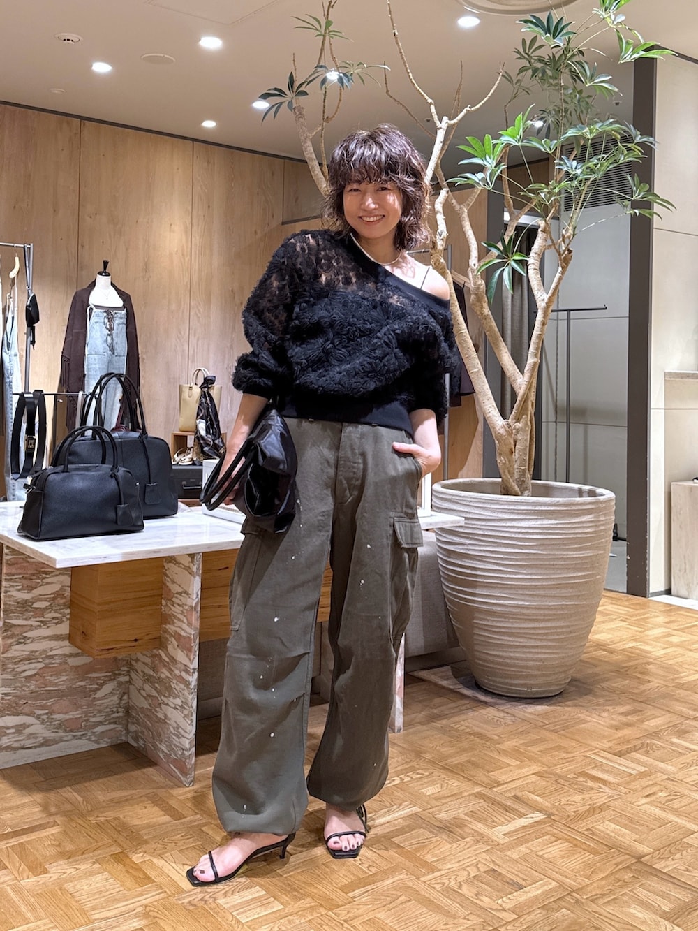 ブラック系のカーディガン/ボレロ、グリーン系のその他パンツ、ブラック系のトートバッグを着用したレディースの夏コーディネートの4枚目の写真