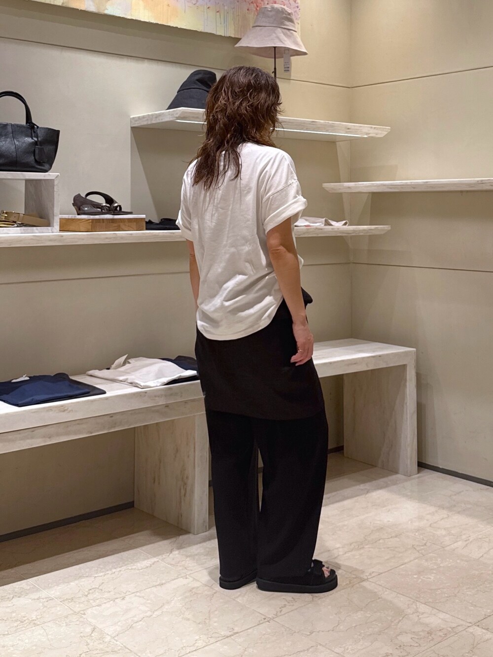 ブラック系のその他パンツ、ホワイト系のTシャツ/カットソー、ブラック系のサンダルを着用したレディースの春コーディネートの2枚目の写真