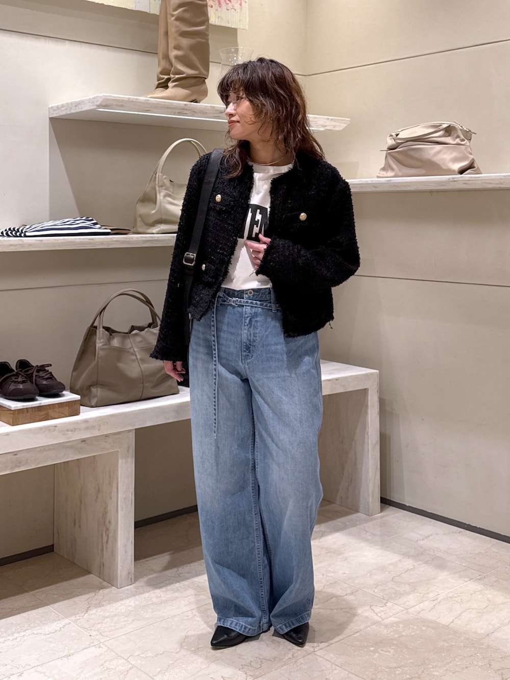 ブラック系のベスト、ホワイト系のTシャツ/カットソー、ブルー系のデニムパンツを着用したレディースの冬コーディネートの2枚目の写真