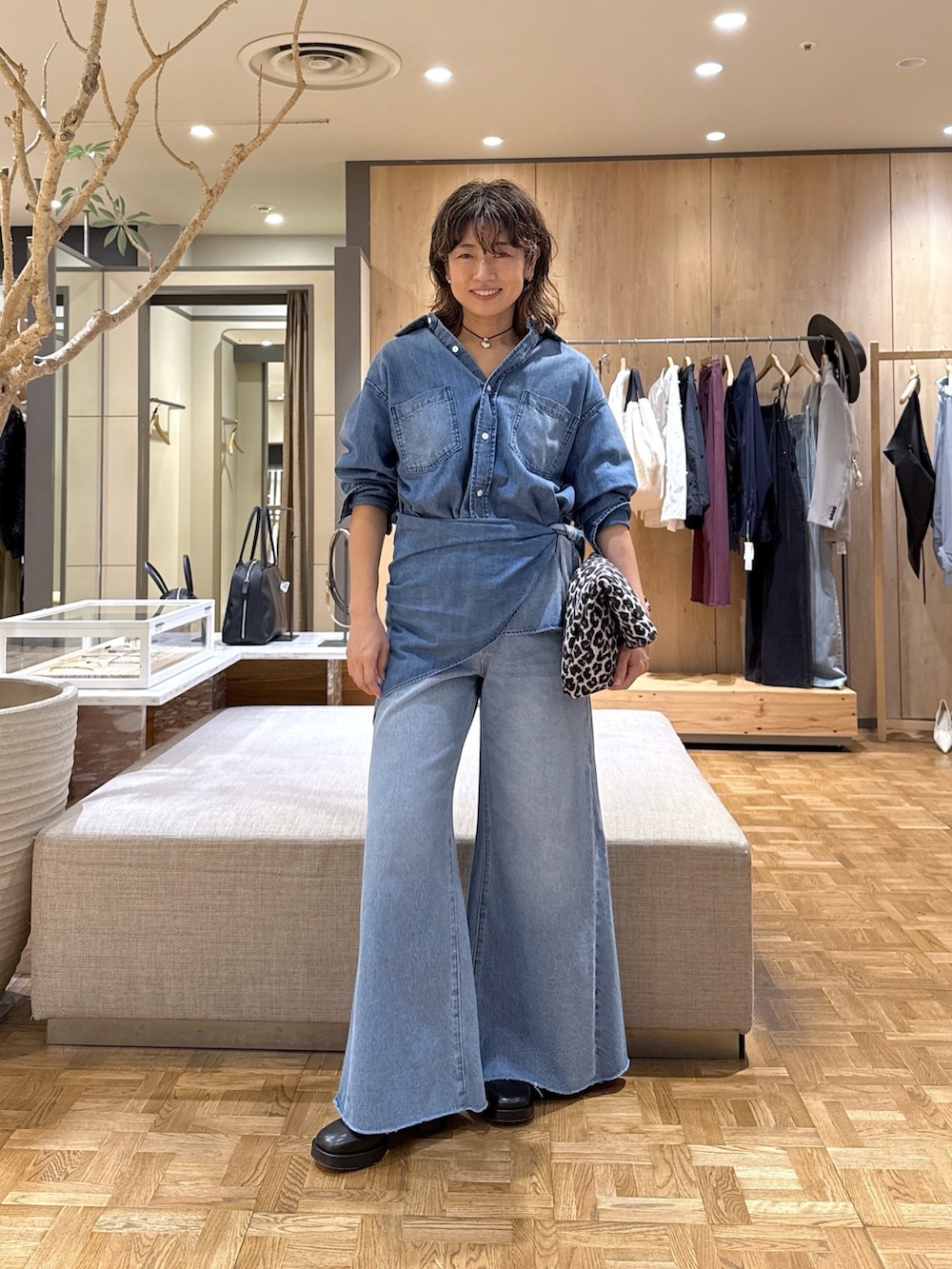 ブルー系のシャツ/ブラウス、ブルー系のデニムパンツ、ブラック系のトートバッグを着用したレディースの秋コーディネートの3枚目の写真