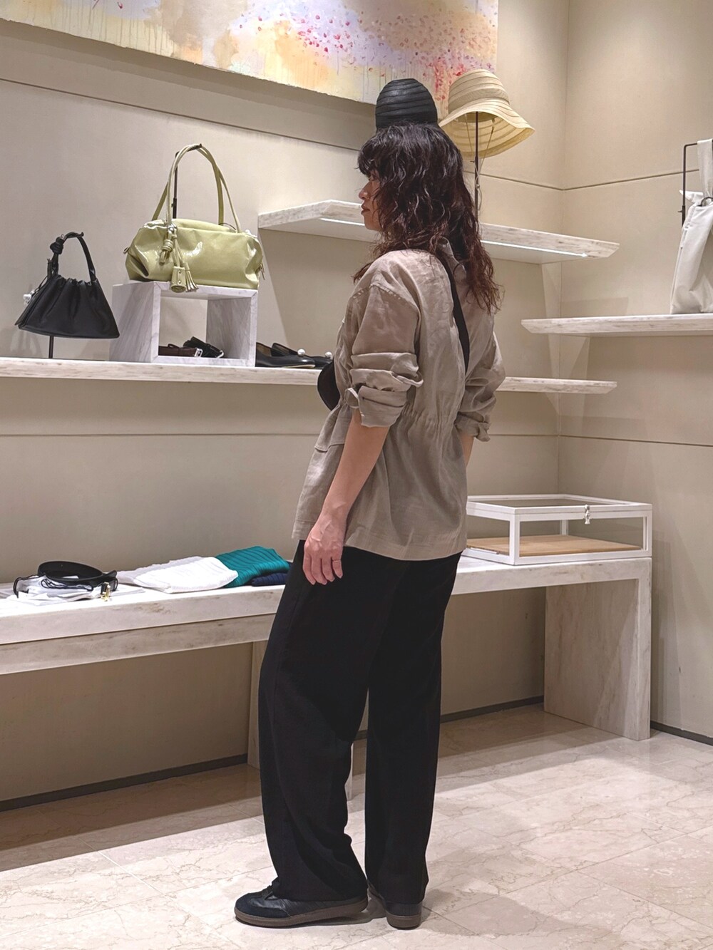 ブラック系のその他パンツ、ブラック系のハンドバッグ、ベージュ系のその他アウターを着用したレディースの春コーディネートの2枚目の写真