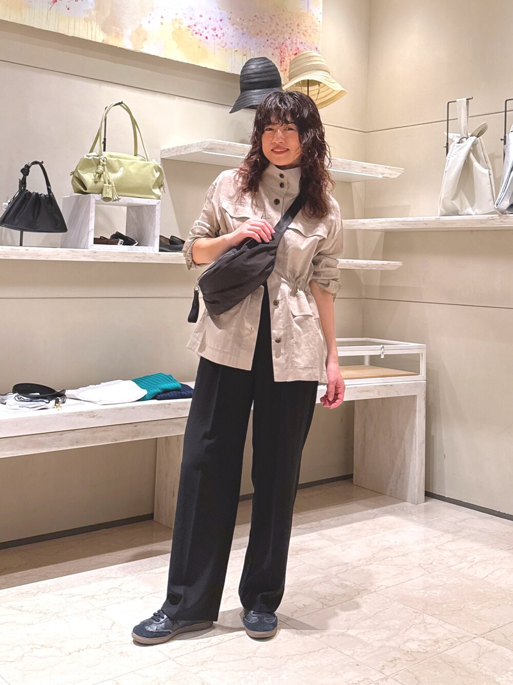 ブラック系のその他パンツ、ブラック系のハンドバッグ、ベージュ系のその他アウターを着用したレディースの春コーディネートの3枚目の写真