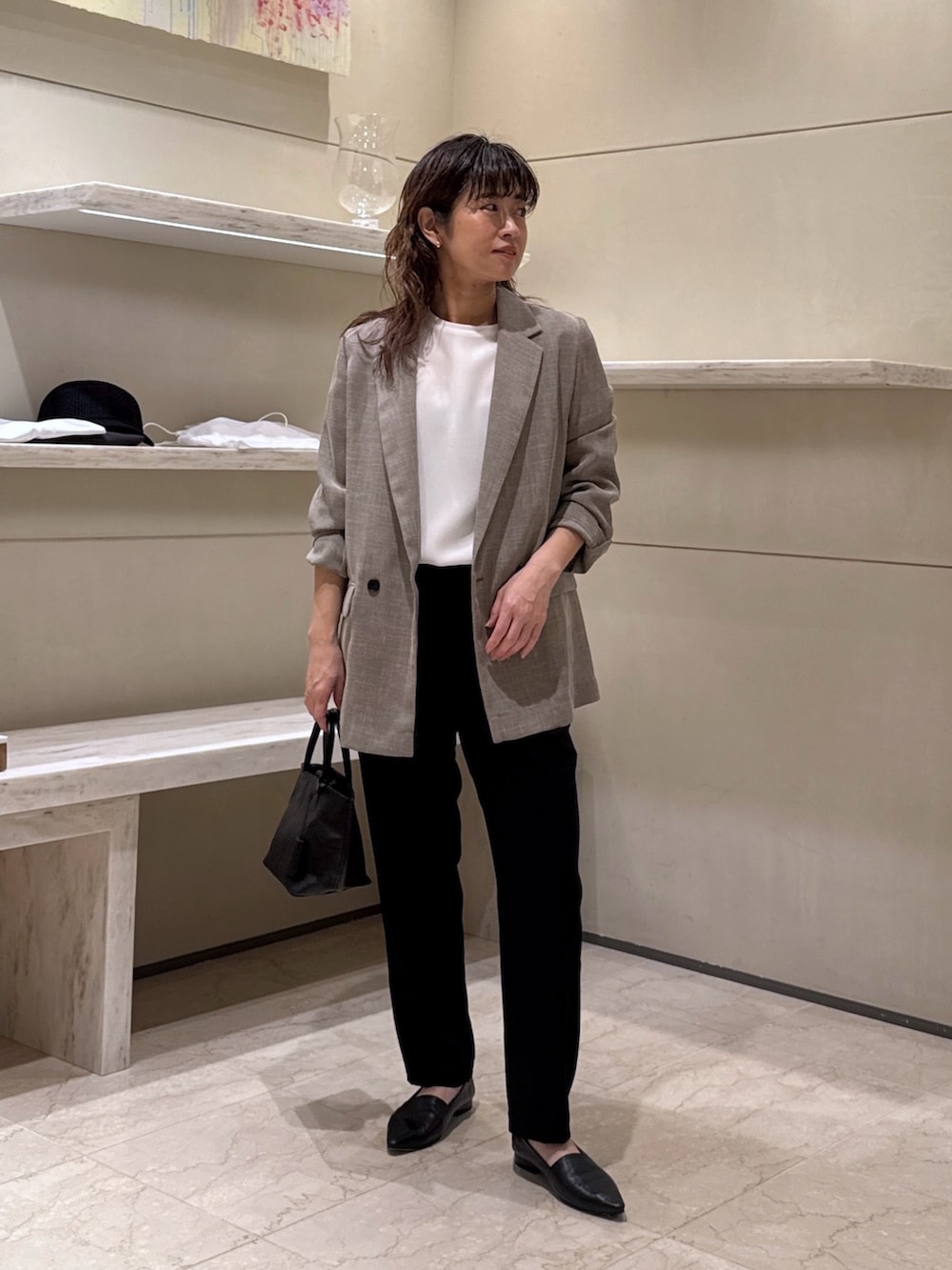 ホワイト系のシャツ/ブラウス、ブラック系のテーラードジャケット、ブラック系のスリッポンを着用したレディースの春コーディネートの2枚目の写真