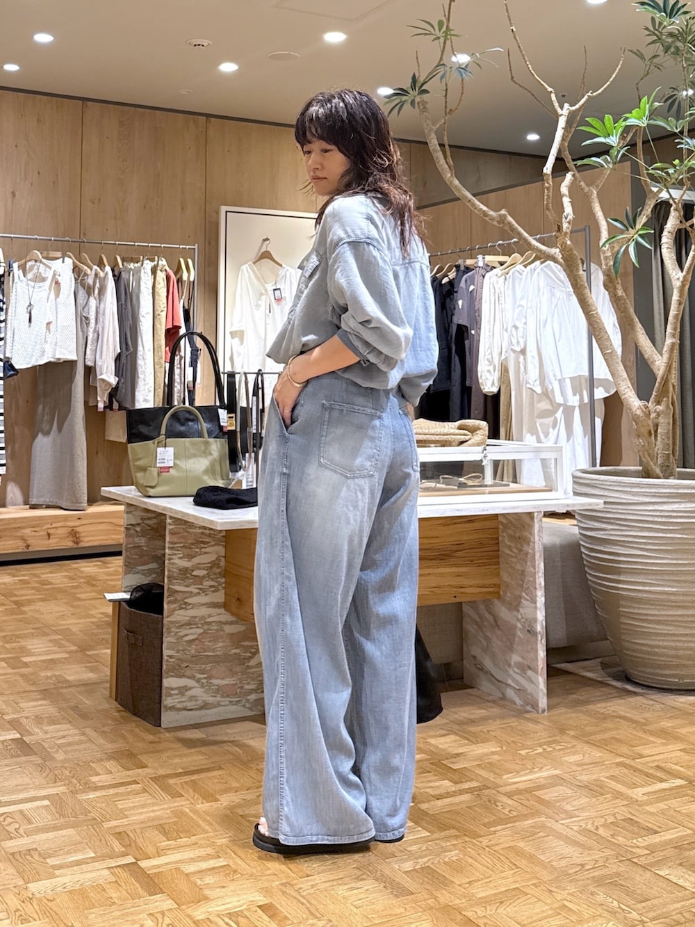 ブルー系のシャツ/ブラウス、ブルー系のその他パンツ、ブラック系のトートバッグを着用したレディースの夏コーディネートの2枚目の写真